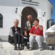 Frau Kramreiter sitzt mit ihrem Gatten und ihrer Cousine draußen auf Stufen in einem weißen andalusischen Bergdorf