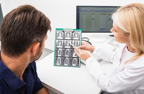 Ärztin bespricht im Krankenhaus mit Patienten die CT Bilder der Lunge