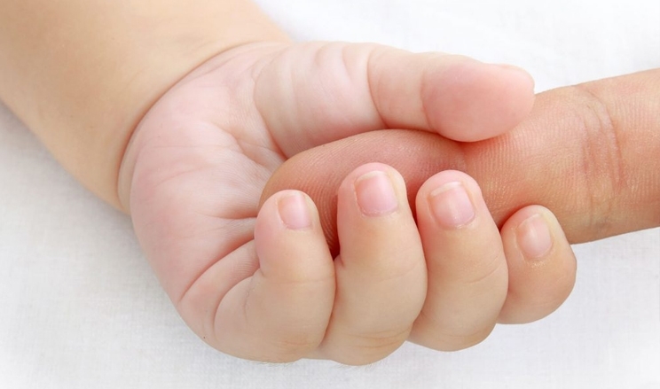 Babyhand hält einen Finger