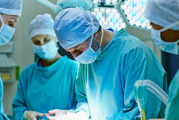 4 Ärzte in einem Operationssaal führen OP durch