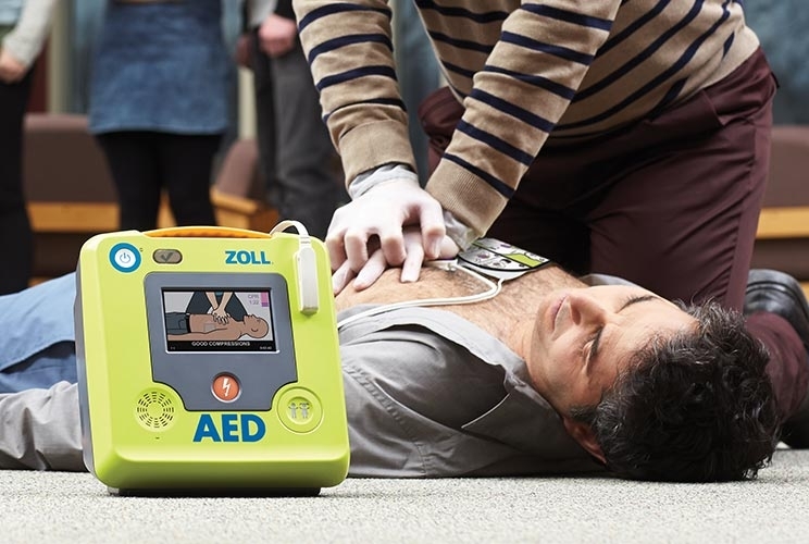 Patient liegt auf dem Boden und wird mit AED 3 Defibrillator reanimiert