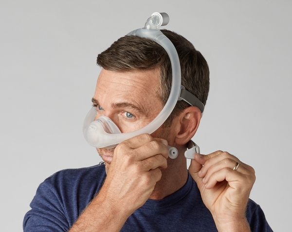 Mann befestigt die Magnetclips seiner DreamWisp Maske