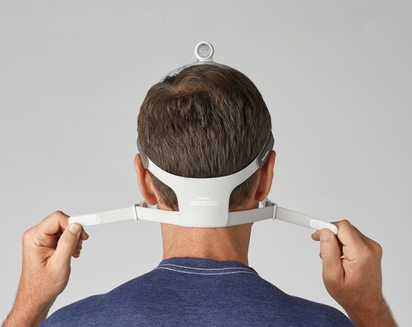 Mann adjustiert das Kopfband seiner DreamWisp Maske