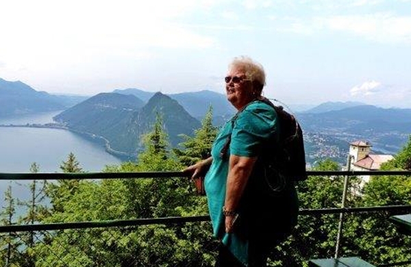 Frau Aschenbrenner genießt den Ausblick auf einen Schweizer Bergsee