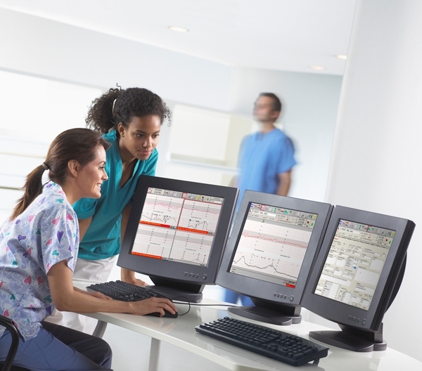 Pflegerinnen sehen auf PC Bildschirme