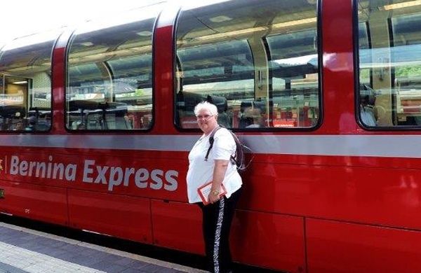 Frau Aschenbrenner vor einem Wagon des Bernina Express 
