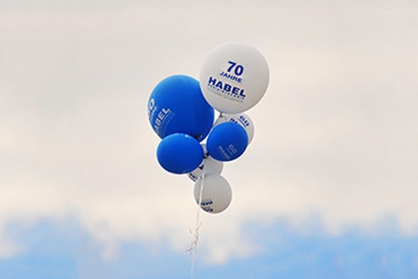 Balloons with "70 years HABEL" print in the sky