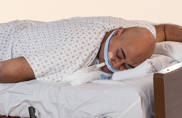 Patient liegt in Krankenhausbett auf dem Bauch mit fixiertem ET-Tubus