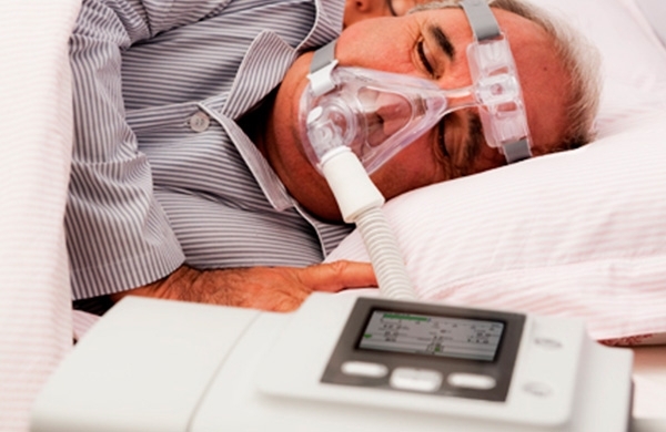 Patient liegt mit CPAP Maske auf der Seite im Bett und wird mit BiPAP A40 Pro beatmet